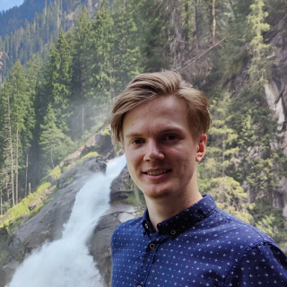 Maxemilian smiling in front of a waterfall